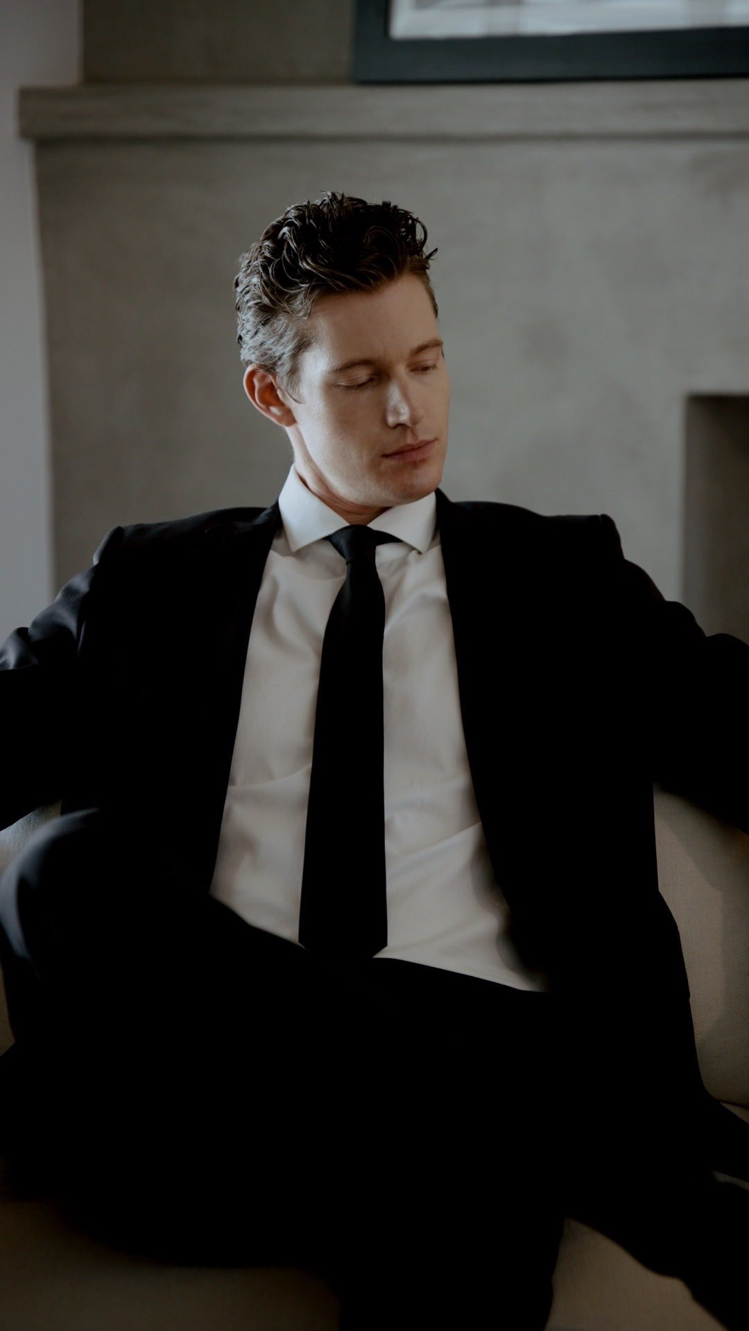 Kasey Esser in a black suit seated in a chair